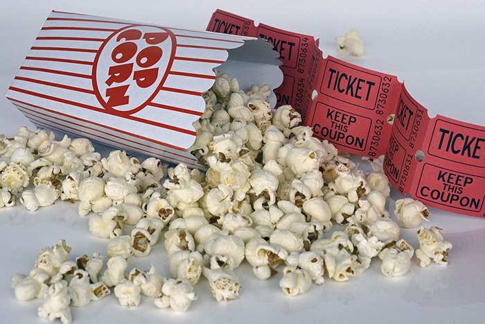 Photo of popcorn and movie tickets as an example of movie reviews