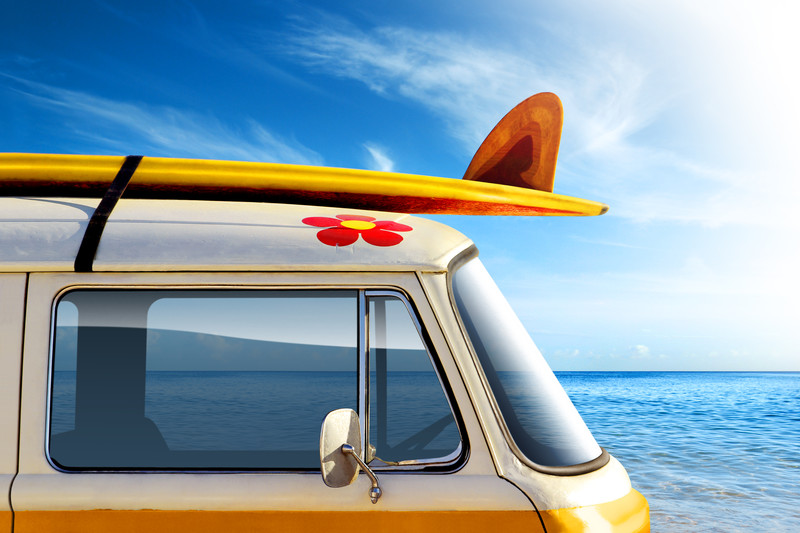 Image of a campervan with a surfboard on the roof