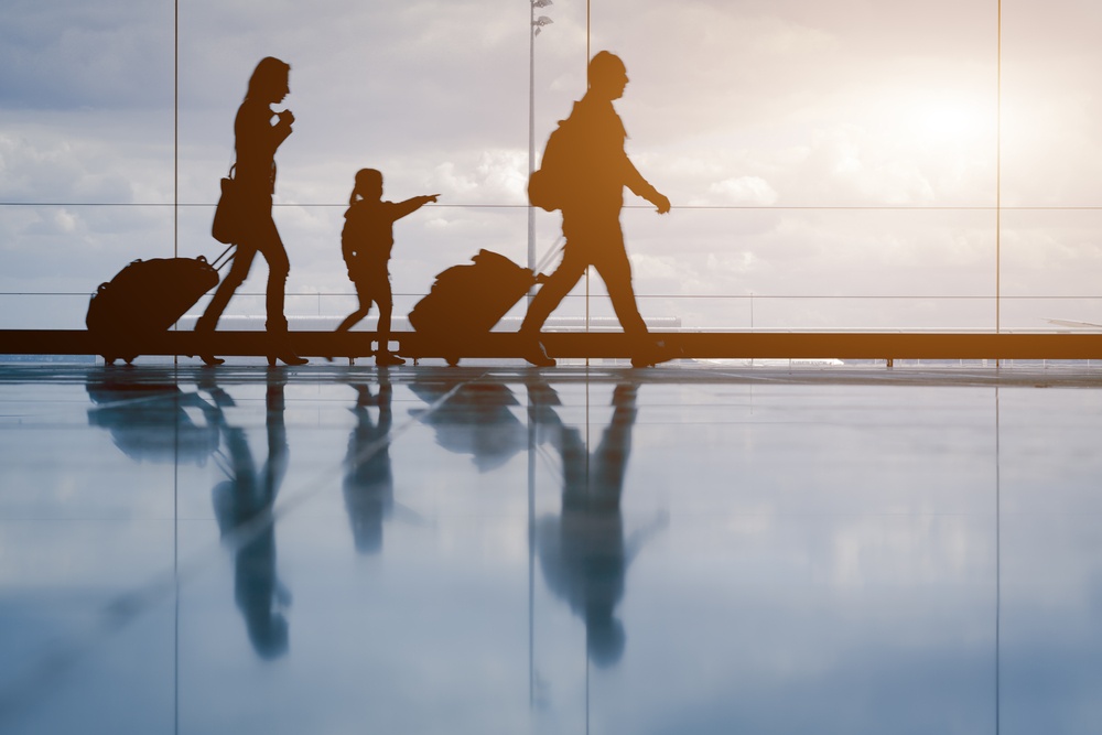 family silhouette in airport with child pointing at sky
