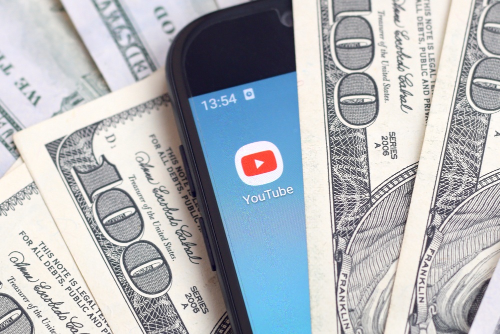 youtube money concept with smartphone in dollar bills