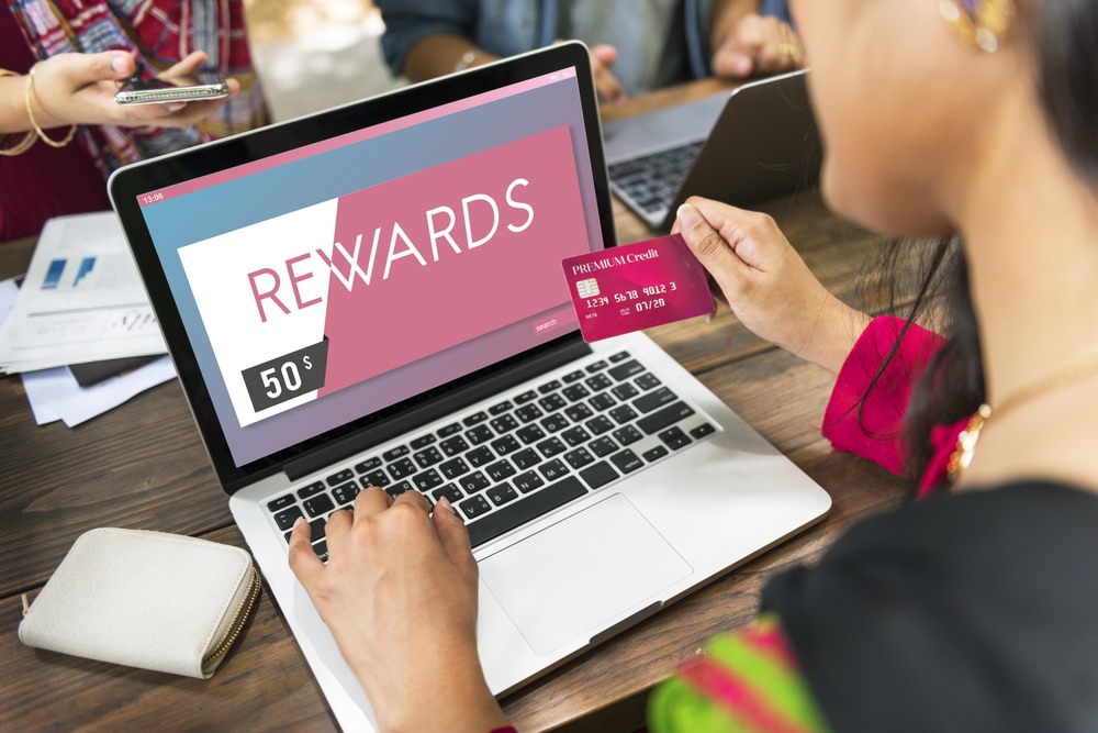 woman looking up credit card rewards on laptop