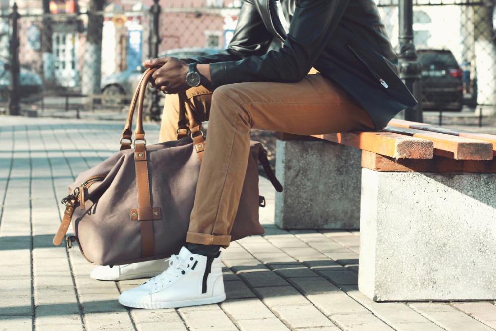 black man wearing stylish sneakers in modern fashion sitting on bench