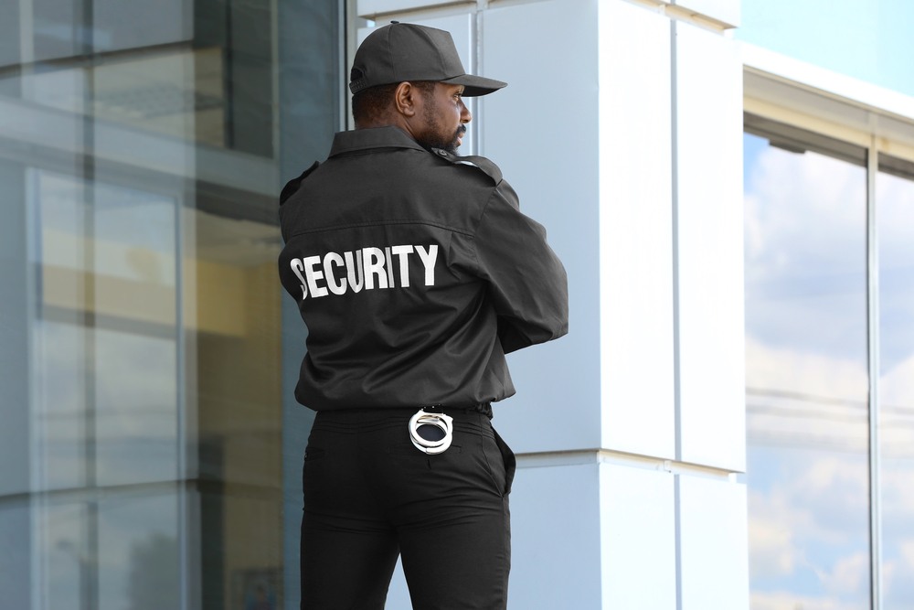 security guard watching corporate property in black jack and black hat