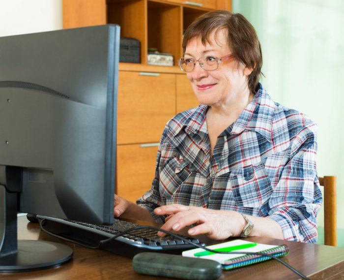 Older woman working at a computer station as an example of jobs for retirees