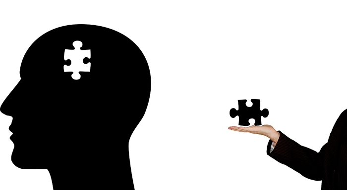 Woman holding a puzzle piece taken from a human silhouette as an example of jobs for psychology majors