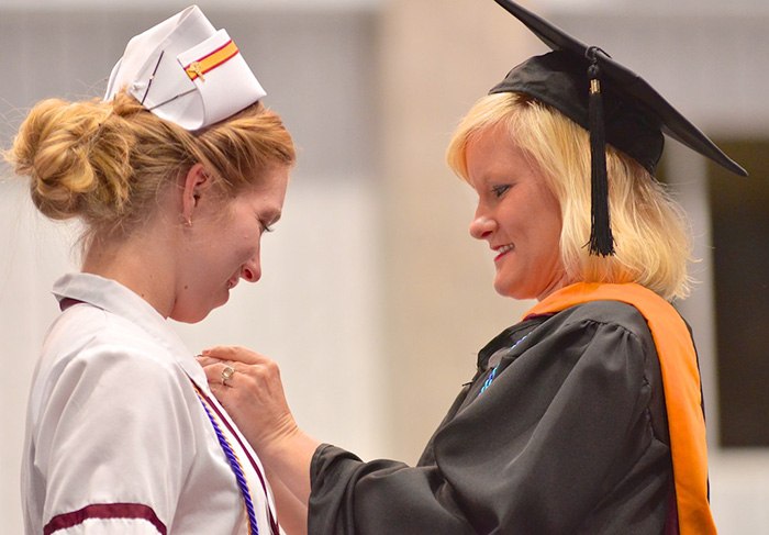 Younger woman attending her nursing graduation ceremony