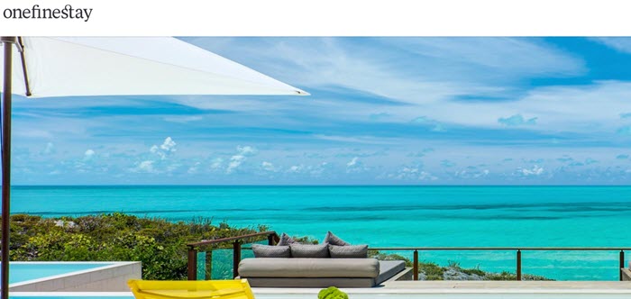 OneFineStay网站截图，展示了从度假屋向清澈的蓝色海洋望去的美丽风景。