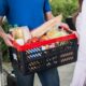 man in blue shirt with a crate full of groceries he's delivering to make money with a food delivery side gig app