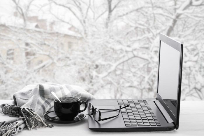 白雪皑皑的冬日橱窗里摆着电脑、咖啡和眼镜，展示着网上写作赚钱的样子