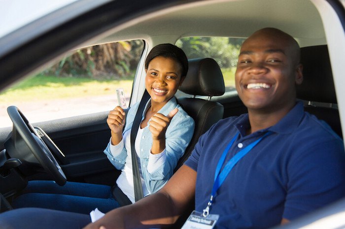 一位年轻的黑人女性通过了驾驶考试，她的驾驶教练代表着最好的非裔美国人附属项目