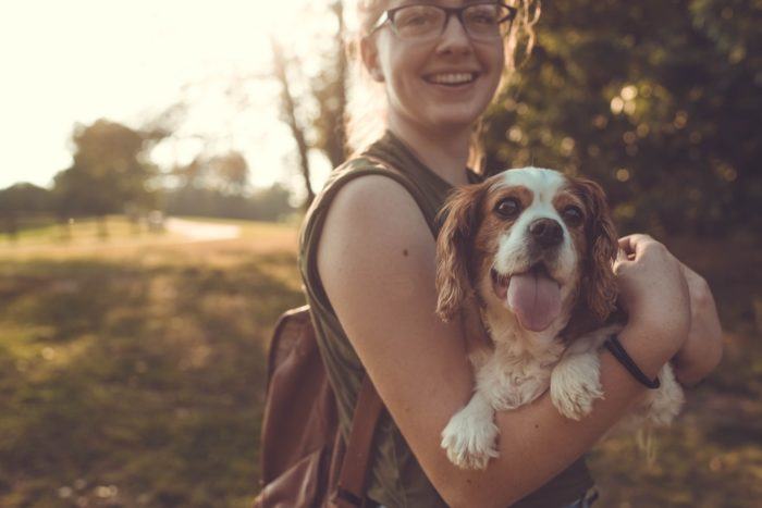 A young woman holding a dog