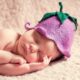 一个刚出生的婴儿戴着一顶针织花帽