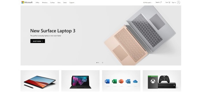 这张微软主页的截图背景是灰色的，上面有一张粉红色笔记本电脑和键盘的照片，灰色笔记本电脑和黑色文字宣布新款Surface laptop 3。
