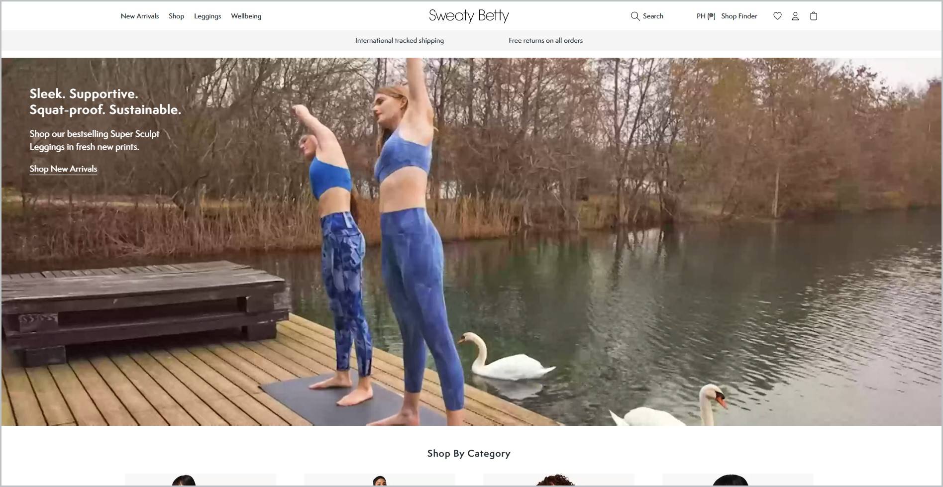 screenshot of Sweaty Betty homepage, with white header with the website's name and main navigation menu, it also features a couple of women wearing sports bra and leggings, stretching on a yoga mat