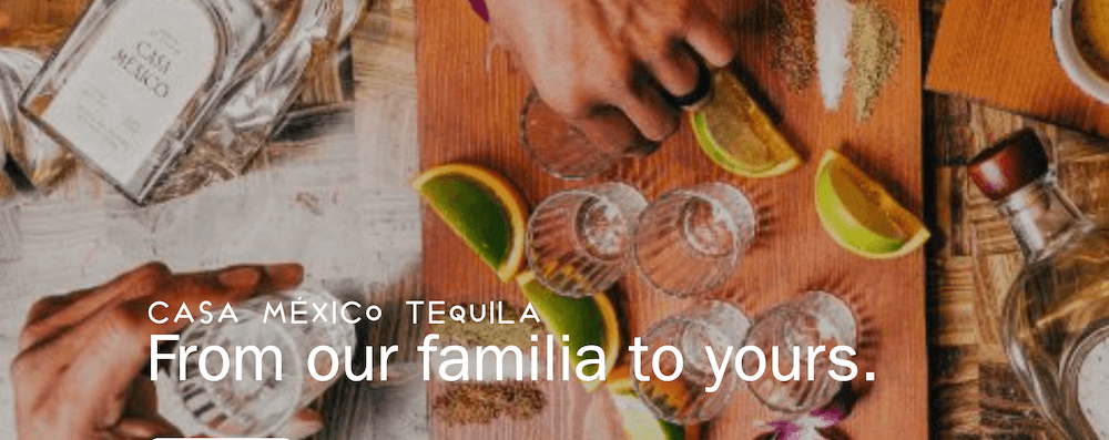 CasaMesico Tequila sits on a table with limes and glasses.